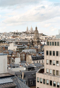 Buildings against cloudy sky