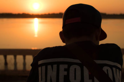 Rear view of silhouette man against sky during sunset