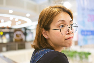 Closeup of young asian woman with blur shopping mall background.