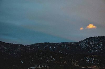 Scenic view of mountains against cloudy sky