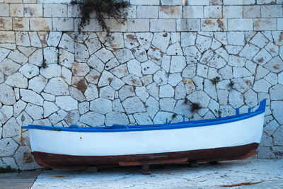 Boat moored against stone wall
