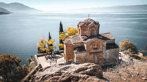 Traditional building by sea against sky