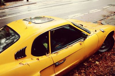 Close-up of yellow car on road