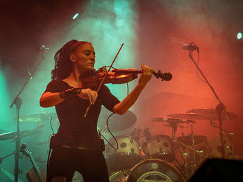 Woman with arms raised in music concert