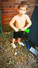 Young man standing on brick wall