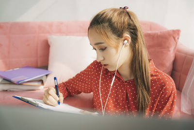 Close-up of girl looking away while sitting on book