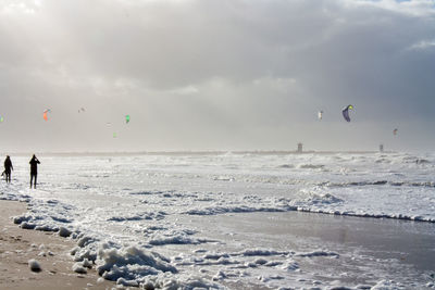 People standing against sea at beach