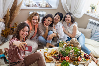 Portrait of happy friends sitting on table