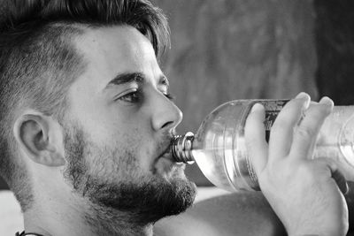 Close-up of young man drinking water
