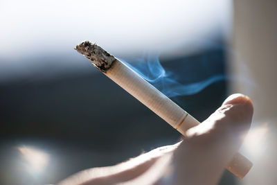 Close-up of hand holding cigarette