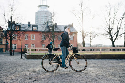 Full length side view of teenage girl wearing hijab cycling in city