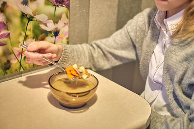 Midsection of woman holding food on table