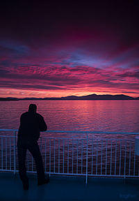 Silhouette of woman in sea at sunset