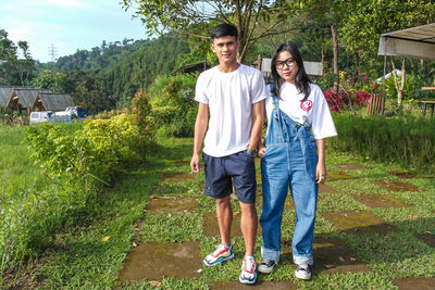 Portrait of young boy and girl standing on field