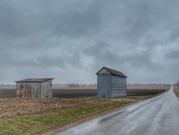 Road amidst agricultural field against sky