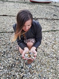 Woman holding pebbles at beach