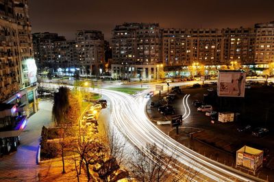 High angle view of light trails on street against buildings at night