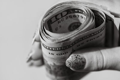 Close-up of hand holding camera against white background