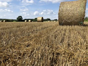 Hay bales on field against sky