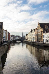 River by buildings in city against sky