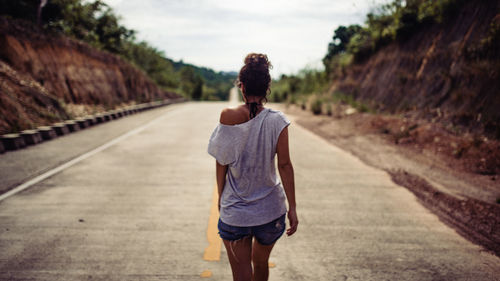 Rear view of woman walking on road