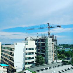 Construction site by buildings against sky