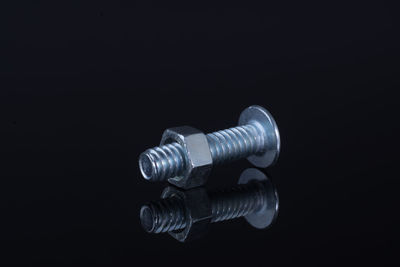 Close-up of machine part against black background