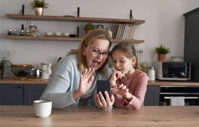 Grandmother and granddaughter talking on video call at home