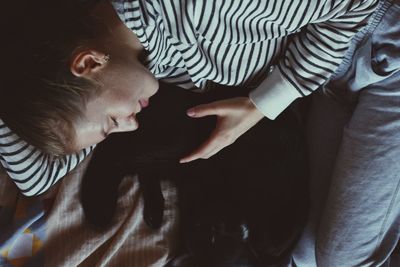 Woman with cat lying on bed