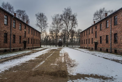 Wet road amidst buildings during winter