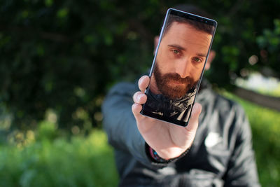 Man showing his face on mobile phone screen