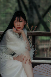 Portrait of young woman standing in hammock