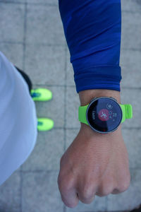 Low section of a nan standing on footpath with his watch ready to run 