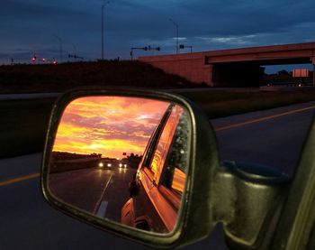 Car on street against orange sky