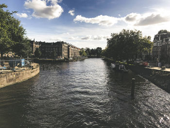 Bridge over river in city against sky