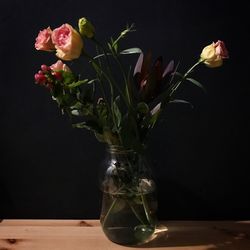 Close-up of flower vase on table against black background