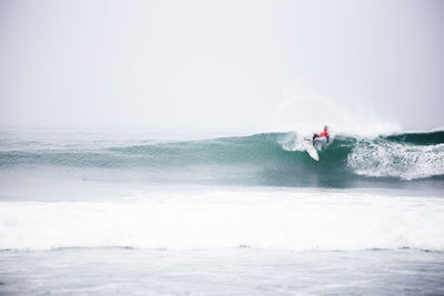 Man surfing on waves in sea