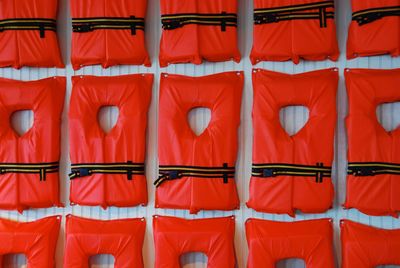 Red lifevests hanging on wall