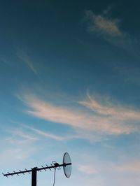 Low angle view of electricity pylon against sky at sunrise