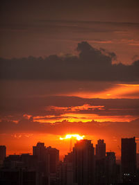 View of cityscape against cloudy sky during sunset