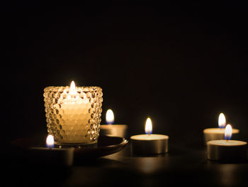 Close-up of lit candle against black background