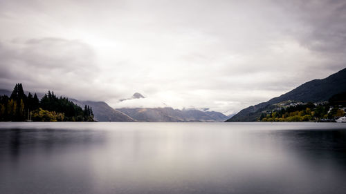 Scenic view of lake and mountains against cloudy sky