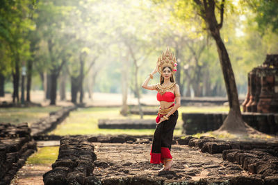 Side view of woman standing by trees