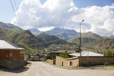 View of the street in stepantsminda, georgia. old houses and mountain view.