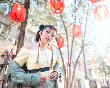 Portrait of young woman holding lantern