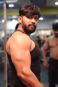 Side view portrait of young man standing at gym