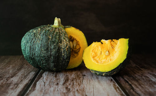 Close-up of fruits on table against black background