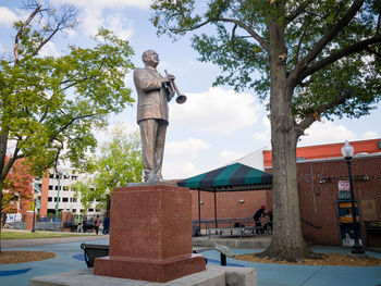 Statue in city against sky