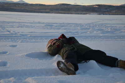 Full length of person lying on snow during winter
