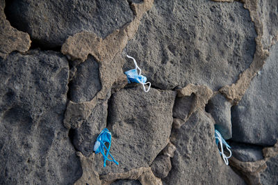 Masks stuck by tourists in the cracks on the cliff of playa de las canteras las palmas de gran